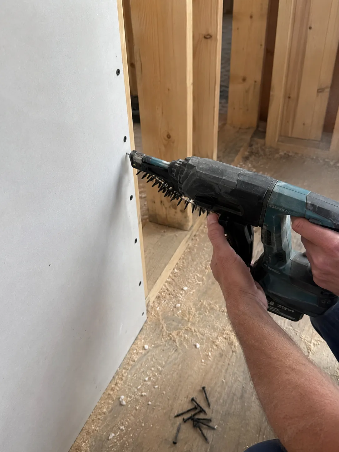 Drywall screw gun fastening a new panel to wall framing on a Las Vegas job
