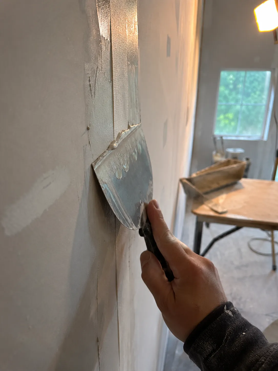 Taping a drywall seam with joint compound and a taping knife